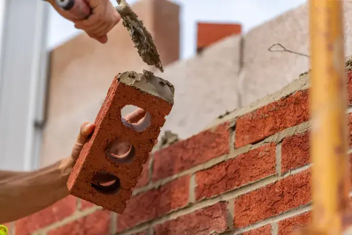 Trowel putting mortar on brick